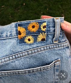 someone is showing off their jeans with sunflowers on the back pocket and side pockets