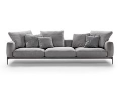 a gray couch with many pillows on it