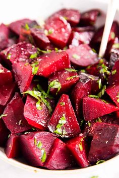 a white bowl filled with beets and herbs