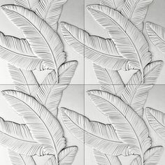 some white tiles with leaves on them and one is drawn in black ink, the other has