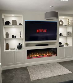 a flat screen tv mounted to the side of a wall next to a fire place