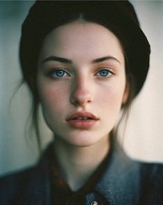 a woman with blue eyes is posing for the camera