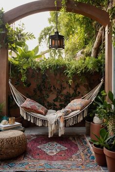 a hammock hanging from the ceiling in an outdoor area with potted plants