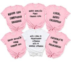 six pink and white shirts with black writing on them