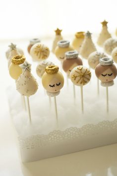 there are many cake pops that have been decorated with gold and silver decorations on them