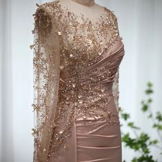 a dress with gold sequins on it and a sheer fabric over the top