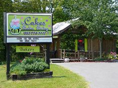 there is a sign that says cake bakery on the side of the road in front of a building