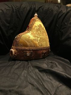 The Doge Hat is the headdress worn by the Doges of Venice and carried over a white cap, similar to the papal camauro, an annual gift of the nuns of San Zaccaria. Composed of a circular crown and a pointed cap in the back, the ducal horn resembled the Phrygian cap worn by Byzantine soldiers and the Venetian dux in ancient times. It was carried, but in a smaller form than that of the Doge, also to crown the golden veil of the Dogaressa, his consort. Over time the various ducal horns have been embe Vintage Ceremonial Costume Hat With High Crown, Ceremonial Costume Hat With Structured Crown, Adjustable Ceremonial Costume Hat With Structured Crown, Traditional Handmade Costume Hats And Headpieces, Traditional Ceremonial Headpiece With Pinched Crown, Traditional Festival Costume Headpieces, Ceremonial Tall Crown Headpiece For Festivals, Traditional Headpieces For Costume Festivals, Traditional Handmade Gold Hat