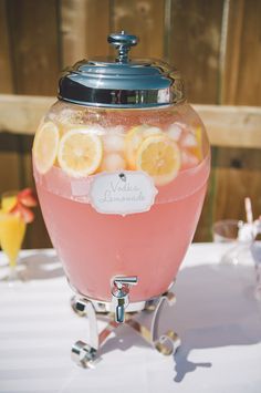 a pitcher filled with lemons and water on top of a table