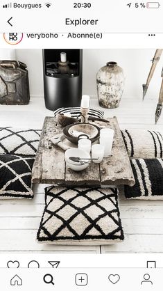 a table with plates and cups on it in the middle of a room filled with rugs