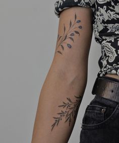 a woman's arm with tattoos on it, and a flower tattoo on the left arm