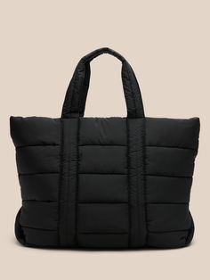 A playful reinterpretation of our puffer coats, this quilted tote has room inside for a laptop, notebook, even a pair of flats.  Plus, our designers added plenty of internal pockets to keep small items — like phones and keys — in easy reach.  Zip Winter Travel Puffer Bags, Trendy Everyday Puffer Bags, Rectangular Puffer Bag For Everyday Use, Trendy Puffer Bag, Puffer Coats, Quilted Totes, Garden Tote, Puffer Coat, Zip Top