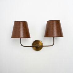 two lamps mounted on the wall next to each other with one light on it's side