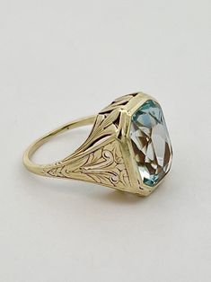 This beautiful cocktail ring comes from an estate and dates back to the late 1800's.  Featuring a magnificent 7.00 carat antique emerald cut Aquamarine, the detailed filigree setting is all 14k yellow gold with engraving and delicate cutouts.  Currently this ring is a size 6, but can be sized to you at no additional charge! Antique Engraved Yellow Gold Ring With Gemstone, Antique Hallmarked Emerald Ring, Formal Rectangular Hallmarked Emerald Ring, Elegant Intaglio Rings For Formal Occasions, Heirloom Jewelry With Intricate Design For Collectors, Antique Yellow Gold Emerald Ring, Victorian Emerald Ring In Yellow Gold, Antique Emerald Ring In Yellow Gold, Victorian Emerald Jewelry In Yellow Gold