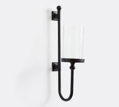 a black wall light with a white shade on it's arm and the bulb turned off