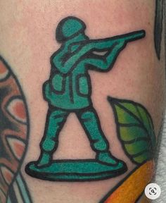 a man with a tattoo on his leg holding a baseball bat and wearing a green uniform