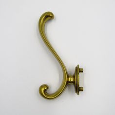 an antique brass hook on a white background