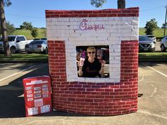 a woman standing in front of a brick wall with a coca - cola sign on it