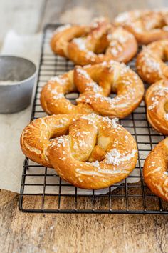 freshly baked doughnuts cooling on a wire rack with powdered sugar sprinkled on top