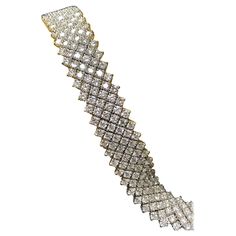 Now this bracelet is absolutely stunning! It has been hand crafted in 18K white gold with each stone individually set and linked in such a way that it moves on the wrist the way water flows. It has been prong set with 231 round diamonds all ranging G-H color and Vs1-Si1 clarity with a total approximate weight of 23.10cttw. There is only so much that one can say to describe this piece, so we prefer to let the pictures and video speak for themselves. Dimensions/Weight Bracelet measures 1.15” wide by 6.90” long. It weighs 35.8g. Condition All stones are secure and clasp functions well. B-SE3 Cocktail Bracelet, Link Bracelets, White Diamond, Picture Video, Chain Bracelet, Prong Setting, Round Diamonds, Jewelry Bracelets, Bracelet