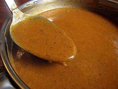 a spoon full of soup sitting on top of a pot