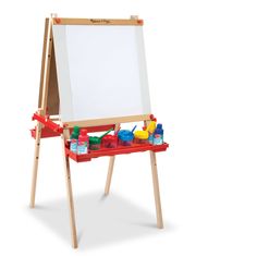 a wooden easel with paint and toys on it's sides, sitting in front of a white background