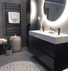 a bathroom with a round mirror above the sink and rug on the floor next to it