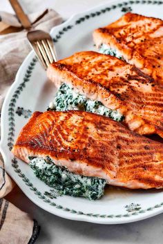 two salmon fillets with spinach on a plate