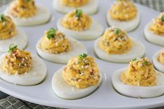 several deviled eggs are arranged on a white plate