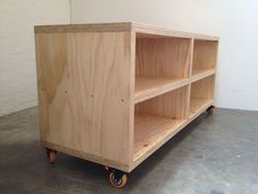 a wooden shelf sitting on wheels in a room