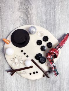 a white plate topped with buttons and other items on top of a wooden table next to an eiffel tower