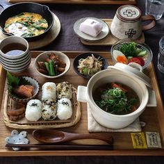 a wooden tray topped with different types of food and drinks on top of a table