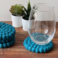 two glass vases sitting on top of a wooden table next to a blue rug