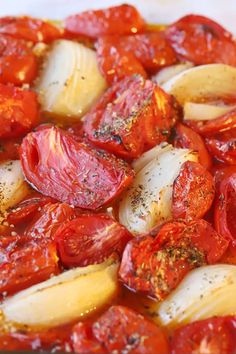 tomatoes and onions cooking in a pan with seasoning on top, ready to be cooked