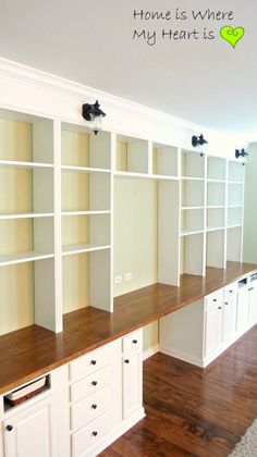 an empty room with white bookcases and wooden floors