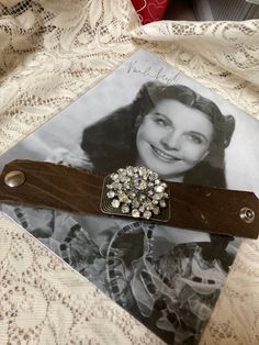 This is an upscale, vintage assemblage bracelet. I started with a vintage leather cuff bracelet with a snap which has been used. For this reason, there is a little bit of stuffing on the side of the leather, which you should be able to see on the photographs. I added a vintage shoeclip in an antique brass color, and then also added a bold rhinestone pin.  It is very flashy and shiny! No returns. Ship to cut a US only. Vintage Leather Concho Bracelets, Vintage Silver Leather Cuff Bracelet, Vintage Adjustable Leather Bracelet With Concho, Vintage Concho Cuff Bracelet, Vintage Leather Bracelet With Concho, Vintage Leather Bracelet Jewelry, Handmade Vintage Brown Leather Bracelet, Handmade Vintage Brown Bracelets, Vintage Brown Leather Jewelry