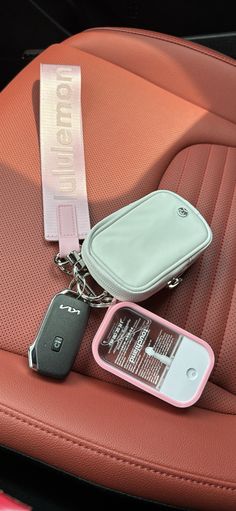 there is a cell phone and keychain on the car seat