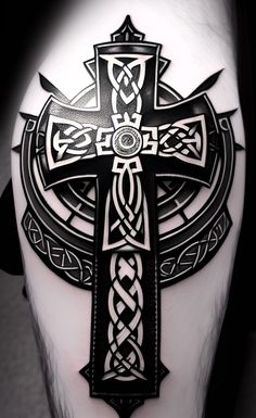 a cross tattoo on the back of a man's leg with celtic patterns and crosses