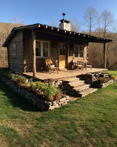 a small wooden cabin sitting on top of a lush green field