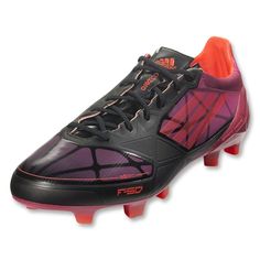 a pair of black and purple soccer shoes with orange accents on the upper part of the shoe