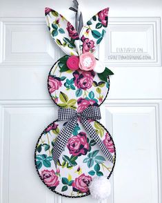 an easter bunny door hanger made out of fabric and paper flowers with a clock on it