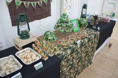 a table topped with lots of food next to a green lantern and wall hangings