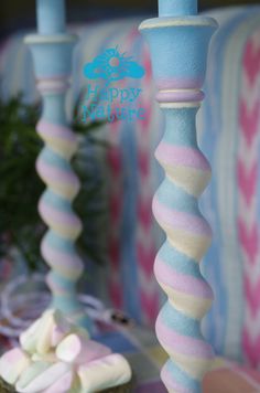 two blue candles with pink and white frosting on them sitting next to each other