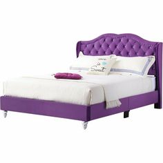 a purple bed with white sheets and pillows on top of the headboard is shown