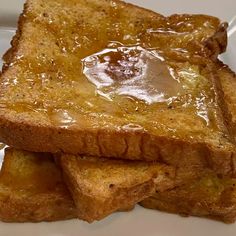 three pieces of french toast on a white plate with caramel sauce in the middle