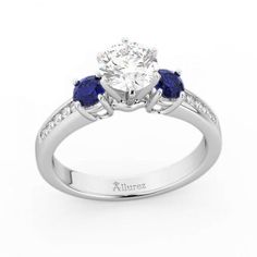 a diamond and blue sapphire engagement ring with two stones on the side, set in 18k white gold