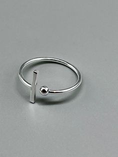 Minimalist ring in real 925 silver. This 925 silver ring with a modern and geometric look with its ball and bar is a classic of jewelry. Sober and minimalist style, this ring will quickly become an essential accessory for your outfits. Ring Size: 7 US - 54 FR They are adjustable, you can enlarge it by a size or tighten it too. Silver 925 real, it is stamped 925. Thin ring, light ring. To preserve the shine of your silver jewelry, it is recommended to: - Avoid contact with water, especially salt Silver Jewelry Minimal, Sterling Silver Minimalist Ring, Silver Rings For Women Stones, Minimalist Silver Ring For Gift, Handmade Silver Minimalist Midi Rings, Ring Stamping, Nickel-free Minimalist Sterling Silver Rings, Minimal Silver Ring, Minimalist Silver Geometric Rings