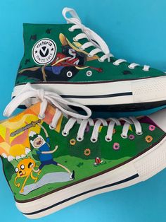 Custom, hand painted canvas boots inspired by your favorite characters from Adventure Time. Perfect for gift at any time of the year, they will not go unnoticed. You can always choose any other type of design or modify to taste the one you are seeing, they are made by freehand and each one is unique. The base color of the shoe is white, the paint is resistant to hand and machine washing but always cold, the color is protected with a coat of fixative at the end of dryer, bleach or other corrosive Fun Hand Painted High-top Custom Sneakers, Fun Hand Painted High-top Sneakers, Fun Hand-painted High-top Sneakers, Green Hand Painted High-top Sneakers, Adventure Time Shoes, Hand Painted Sneakers, Custom Painted Shoes, Painted Sneakers, Custom Converse