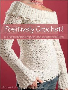 a woman wearing a white sweater with the words positively crochet on it