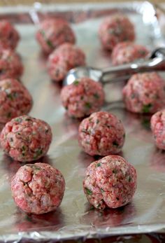 raw meatballs on a baking sheet ready to be cooked